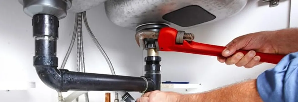 Garbage disposal repair technician tightening the sink drain and disposal connection in Bradenton, FL