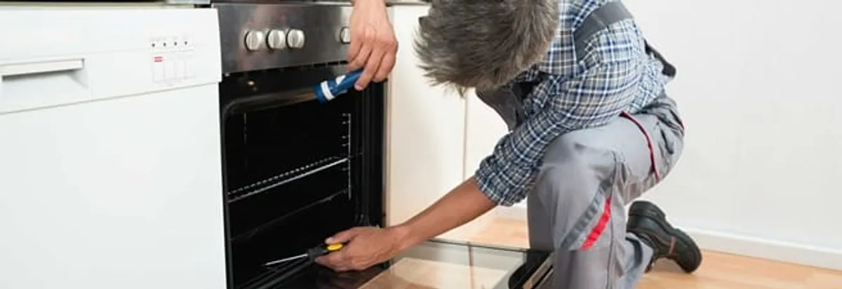 Oven repair technician inspecting and servicing an electric oven in Bradenton, FL
