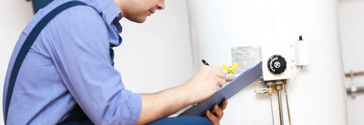 Water heater repair technician inspecting the unit and recording service notes in Bradenton, FL
